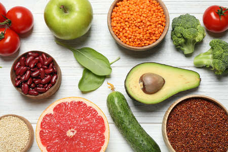Different vegetables, seeds and fruits on white wooden table, flat lay. healthy dietの写真素材