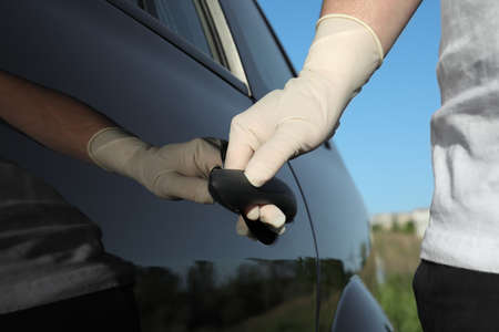 Man in gloves opening car door, closeup view