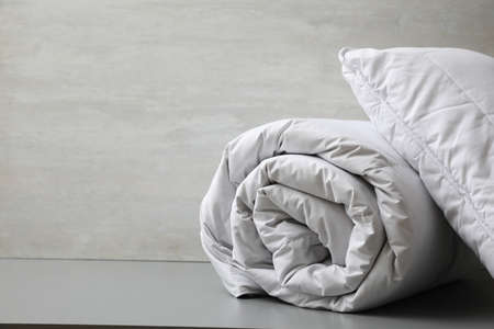 Soft blanket and pillow on light gray table, closeup. Space for textの写真素材