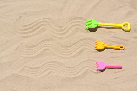 Plastic rakes on sand, space for text. beach toysの写真素材