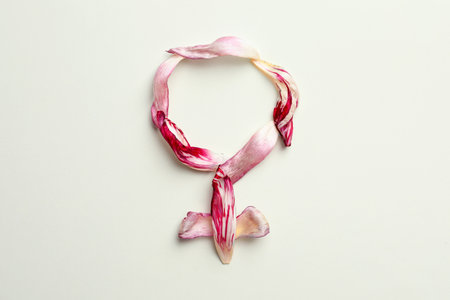 Female gender sign made of tulip petals on beige background, top view. menopause concept
