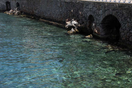 Beautiful view of stone wall near sea on sunny dayの写真素材