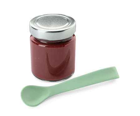 Jar of healthy baby food and spoon on white backgroundの写真素材