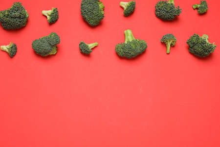 Fresh tasty broccoli on red background, flat lay. Space for text