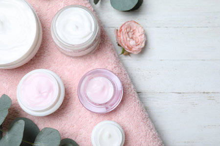 Flat lay composition with jars of cream on white wooden tableの写真素材