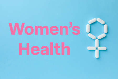 Words Women's Health and female symbol made of pills on light blue background, flat layの写真素材