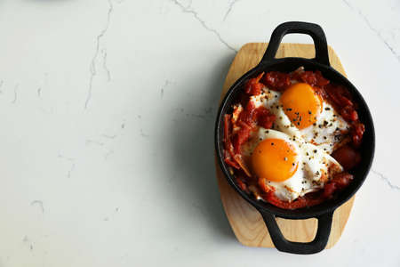 Tasty Shakshouka served on white marble table, top view. Space for textの写真素材