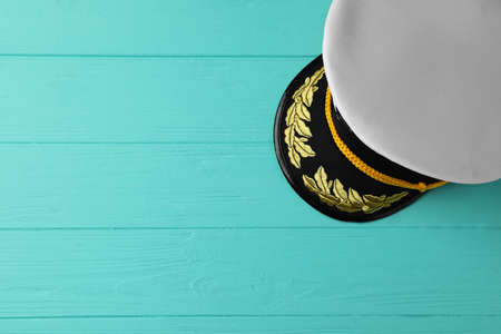 Peaked cap with accessories on turquoise wooden background, top view. Space for textの写真素材