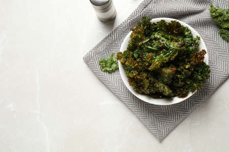 Tasty baked kale chips on gray marble table, flat lay. Space for textの写真素材