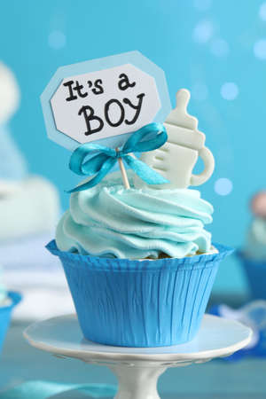 Beautifully decorated baby shower cupcake for boy with cream and topper on light blue background, closeupの写真素材