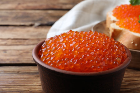 Bowl with delicious red caviar on wooden table, closeupの写真素材