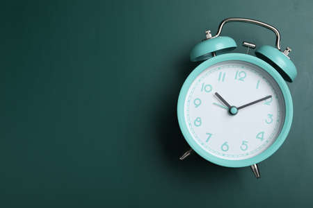 Alarm clock on green chalkboard, top view with space for text. school timeの写真素材