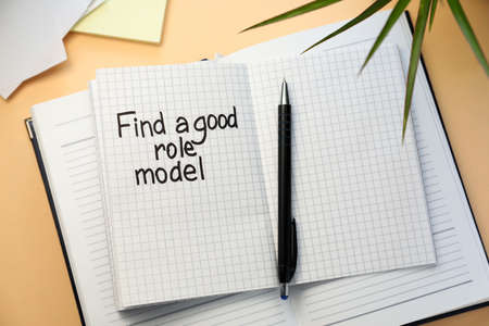 Notebook with phrase Find A Good Role Model and pen on beige background, flat layの写真素材