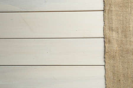 Natural burlap fabric on white wooden table, top view. Space for textの写真素材