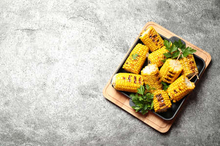 Tasty grilled corn on gray table, top view. Space for textの写真素材