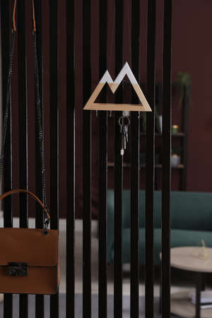 Key holder on black wooden folding screen in roomの写真素材