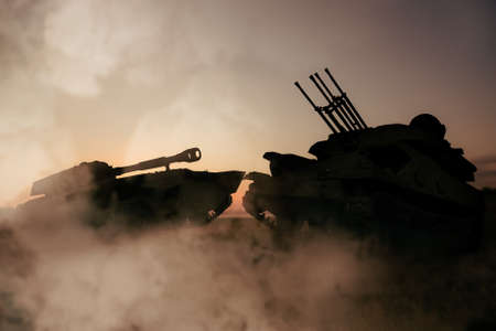 Silhouettes of armored fighting vehicle and tank on battlefieldの写真素材