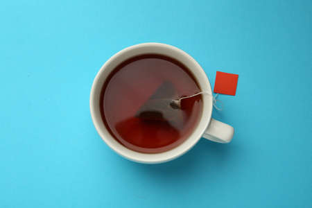 Tea bag in cup of hot water on light blue background, top viewの写真素材