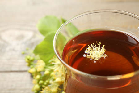 Cup of tea with linden blossom on table, closeup. Space for textの写真素材