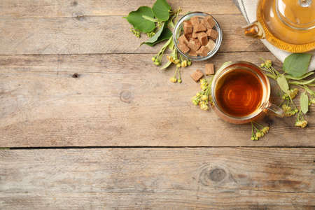 Flat lay composition with tasty tea and linden blossom on wooden table. Space for textの写真素材