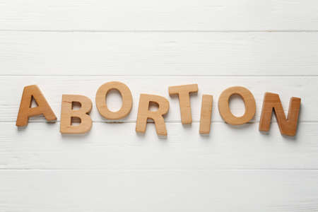 Word Abortion made of letters on white wooden background, flat layの写真素材