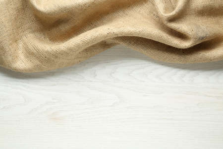 Natural burlap fabric on white wooden table, top view. Space for textの写真素材
