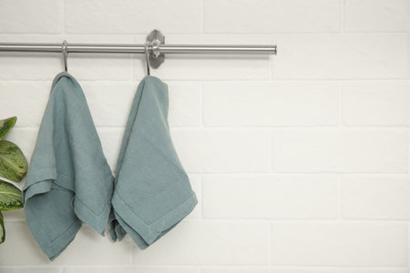 Clean kitchen towels hanging on rack. Space for textの写真素材