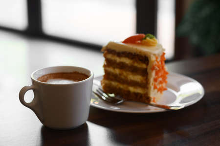 Cup of hot coffee and delicious cake on wooden table, closeupの写真素材