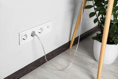 Power socket and plug on wall indoors. Electrician's equipmentの写真素材