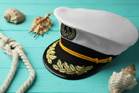 Peaked cap, rope and shells on turquoise wooden backgroundの写真素材