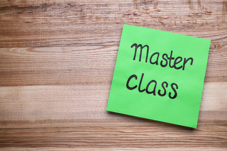 Green paper note with words Master Class on wooden table, top view. Space for textの写真素材