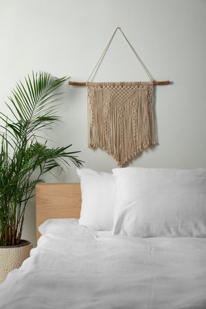 Stylish macrame hanging on white wall in the bedroomの写真素材
