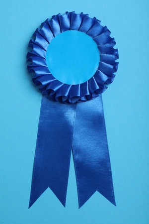 Blue award ribbon on turquoise background, top viewの写真素材
