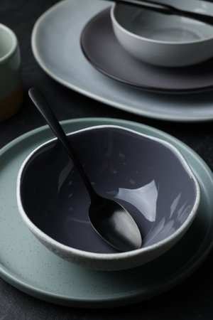 Set of clean tableware on black tableの写真素材