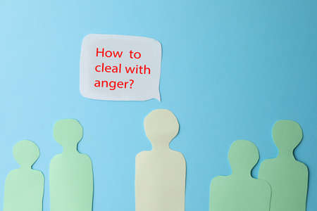 Paper cutout of crowd and speech bubble with inscription How To Deal With Anger? on light blue background, flat lay. Emotional managementの写真素材