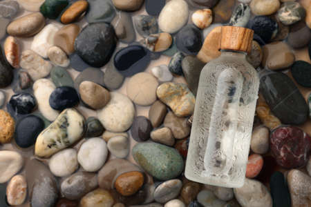 Bottle of cosmetic product on wet stones, top view. Space for textの写真素材