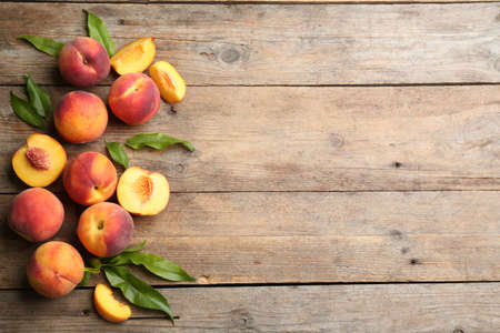 Fresh sweet peaches on wooden table, flat lay. Space for textの写真素材