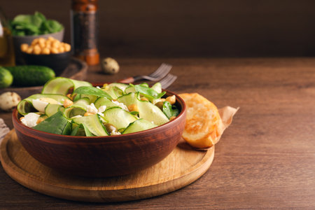 Delicious cucumber salad and rosted bread served on wooden table. Space for textの写真素材