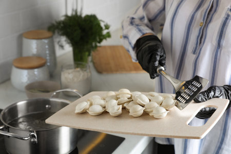 Woman cooking delicious dumplings in kitchen, closeupの写真素材