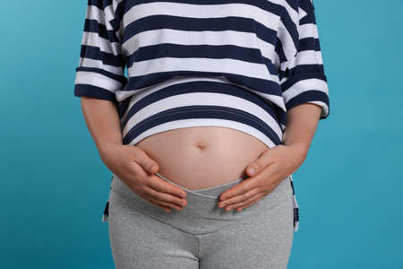 Pregnant woman on light blue background, closeupの写真素材
