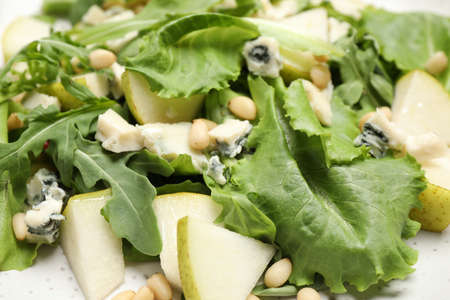 Tasty salad with pear slices, lettuce and pine nuts as background, closeupの写真素材
