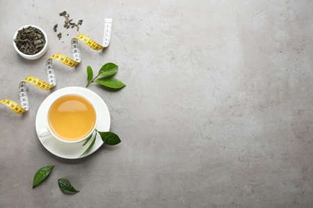 Flat lay composition with herbal diet tea and measuring tape on light table. Space for textの写真素材