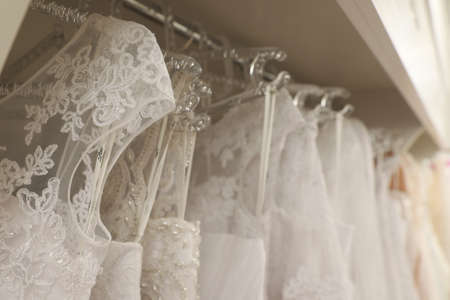 Different wedding dresses on hangers in boutique, closeupの写真素材