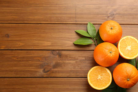 Delicious ripe oranges on wooden table, flat lay. Space for textの写真素材