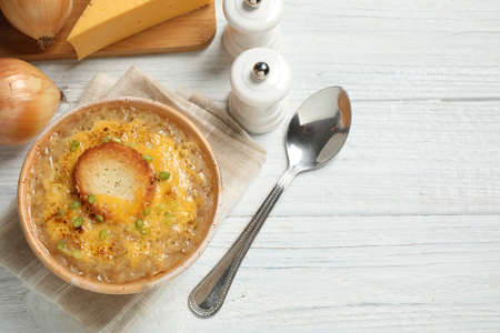 Tasty homemade french onion soup served on white wooden table, flat lay. Space for textの写真素材