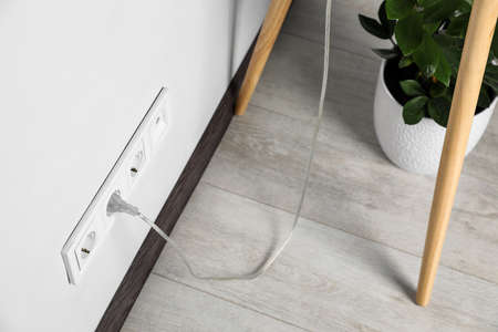 Power socket and plug on wall indoors. Electrician's equipment