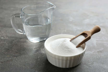 Baking soda in bowl on gray tableの写真素材