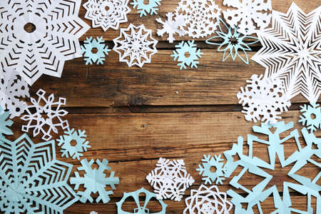 Many paper snowflakes on wooden background, flat lay. Space for textの写真素材