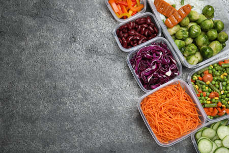 Set of plastic containers with fresh food on gray table, flat lay. Space for text