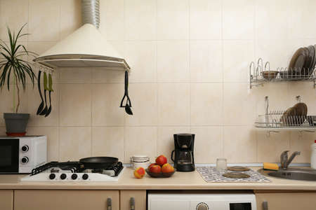 Stylish kitchen interior with different modern appliances and apples